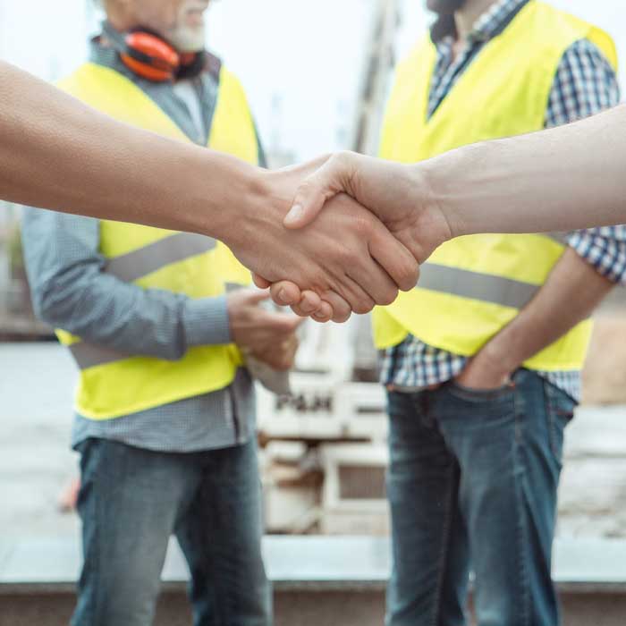 Workmen shaking hands on a building project