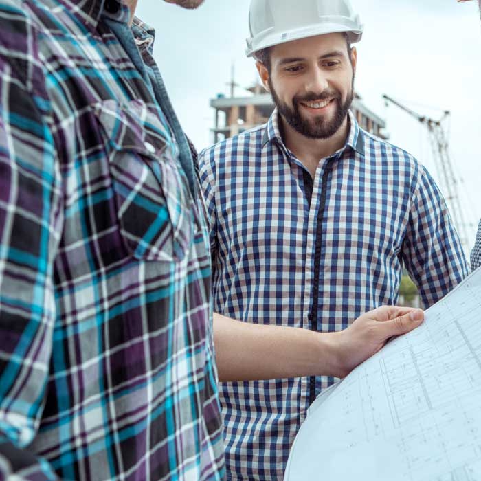 Workmen discussing architect plans on a building project